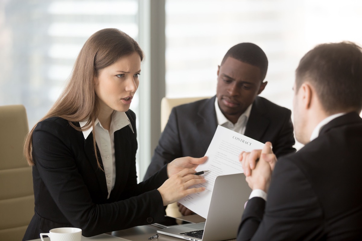 Angry dissatisfied businesswoman holding contract arguing with contractor, pointing at terms failed to perform, demanding termination, loss compensation, defrauded cheated investor protecting rights, forced arbitration concept