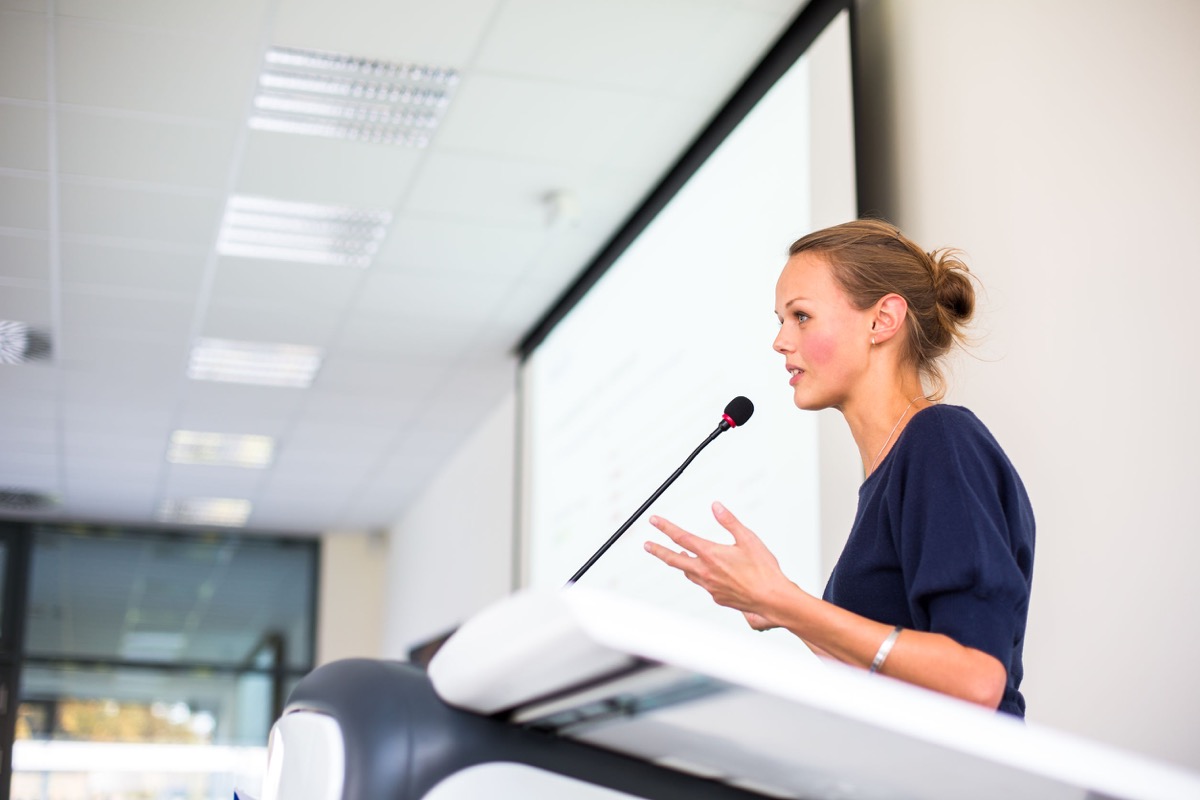 Pretty young business woman giving a presentation in a conference/meeting setting (shallow DOF; color toned image)