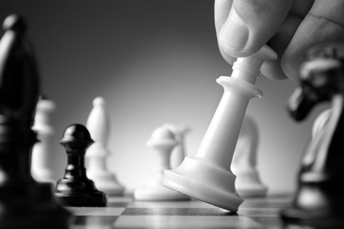 Conceptual image depicting making a strategic move with a hand moving a chess piece on a chessboard during a game of skill. Here representing the win for unions in the Dynamex decision