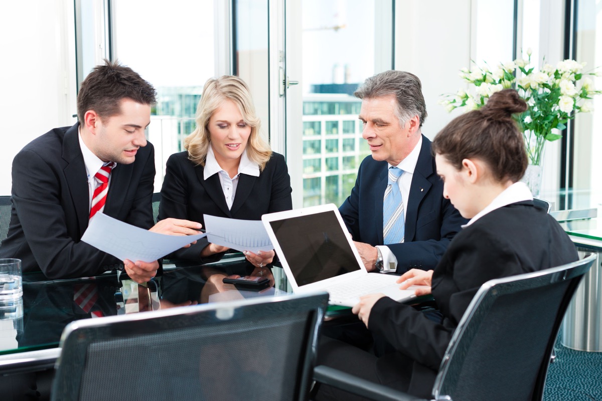 Business - meeting in an office, the businesspeople are discussing a document; representing why unions must protect workers form automation
