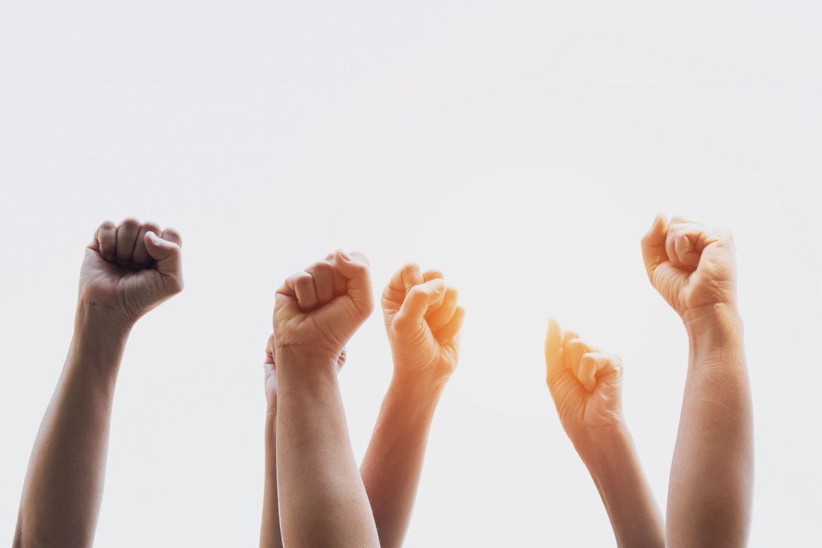 Group people of fists raised with sunlight; unions and the 2020 presidential election concept