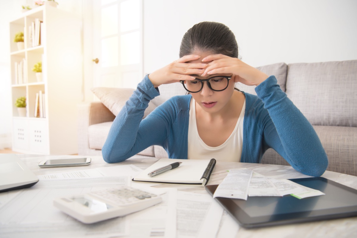 stressed worried young woman doing banking; need for cost-of-living increases concept
