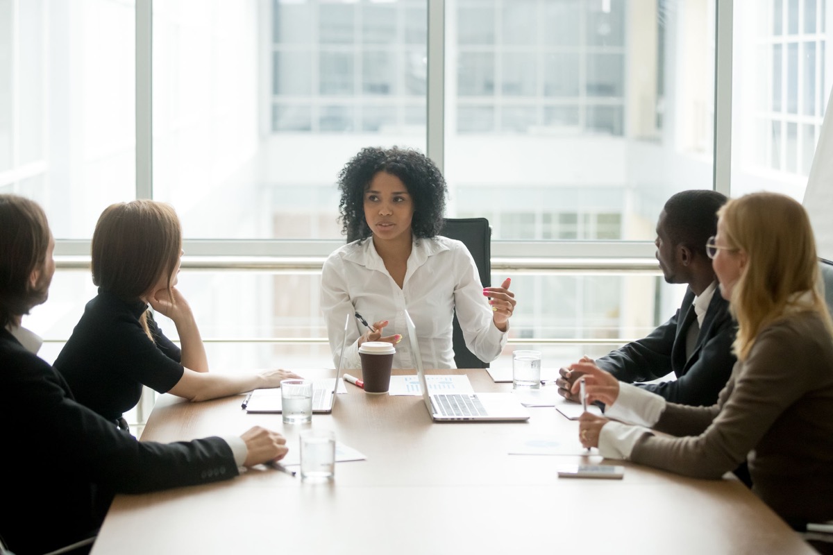 boss leading multiracial team business meeting; workplace diversity and collective bargaining agreements concept
