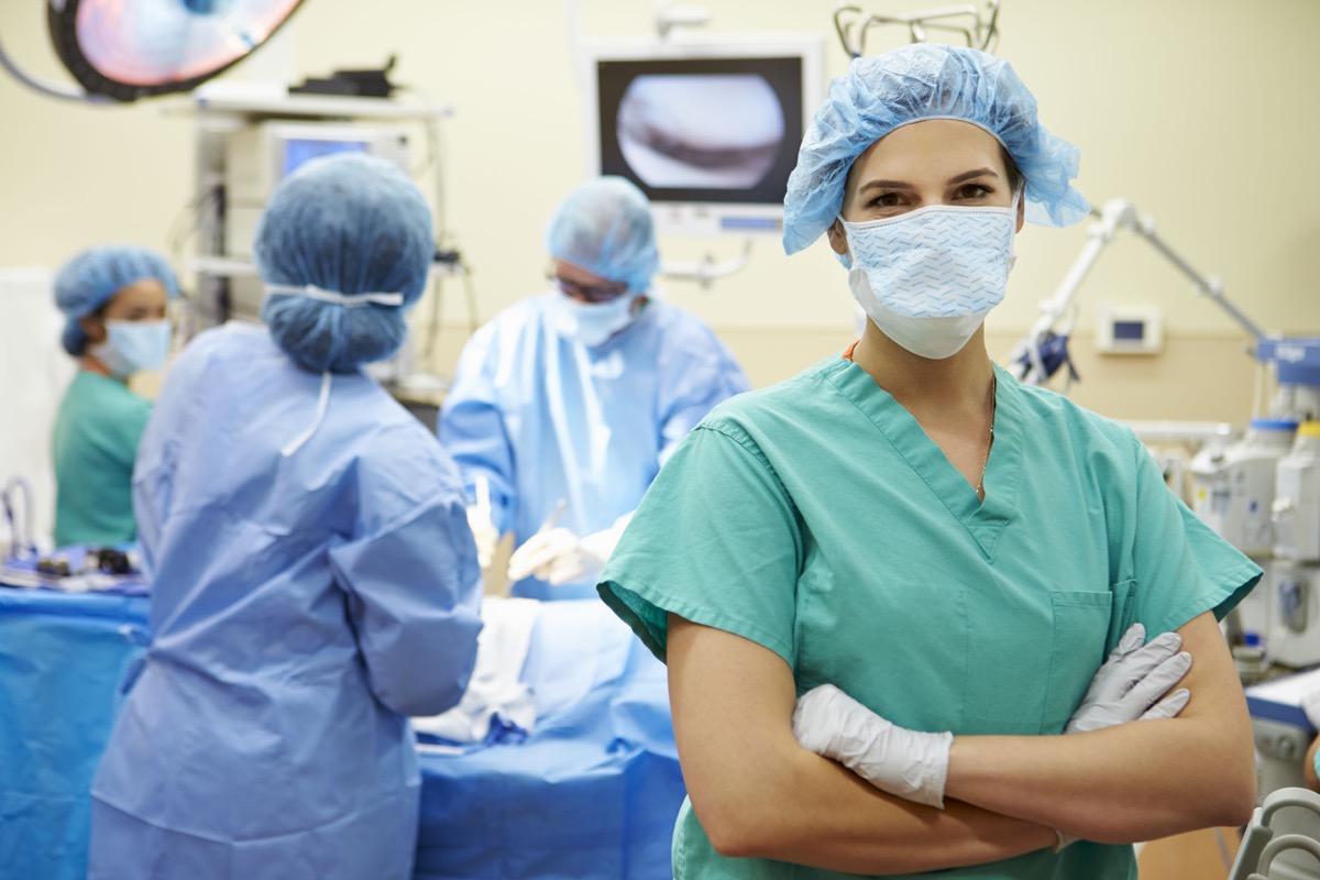 Portrait Of Nurse Working In Operating Theatre; essential workers concept