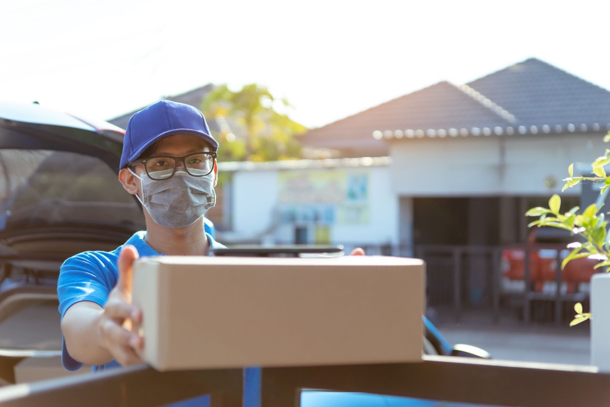 Asian Delivery man wearing mask holding parcel; Front-line workers