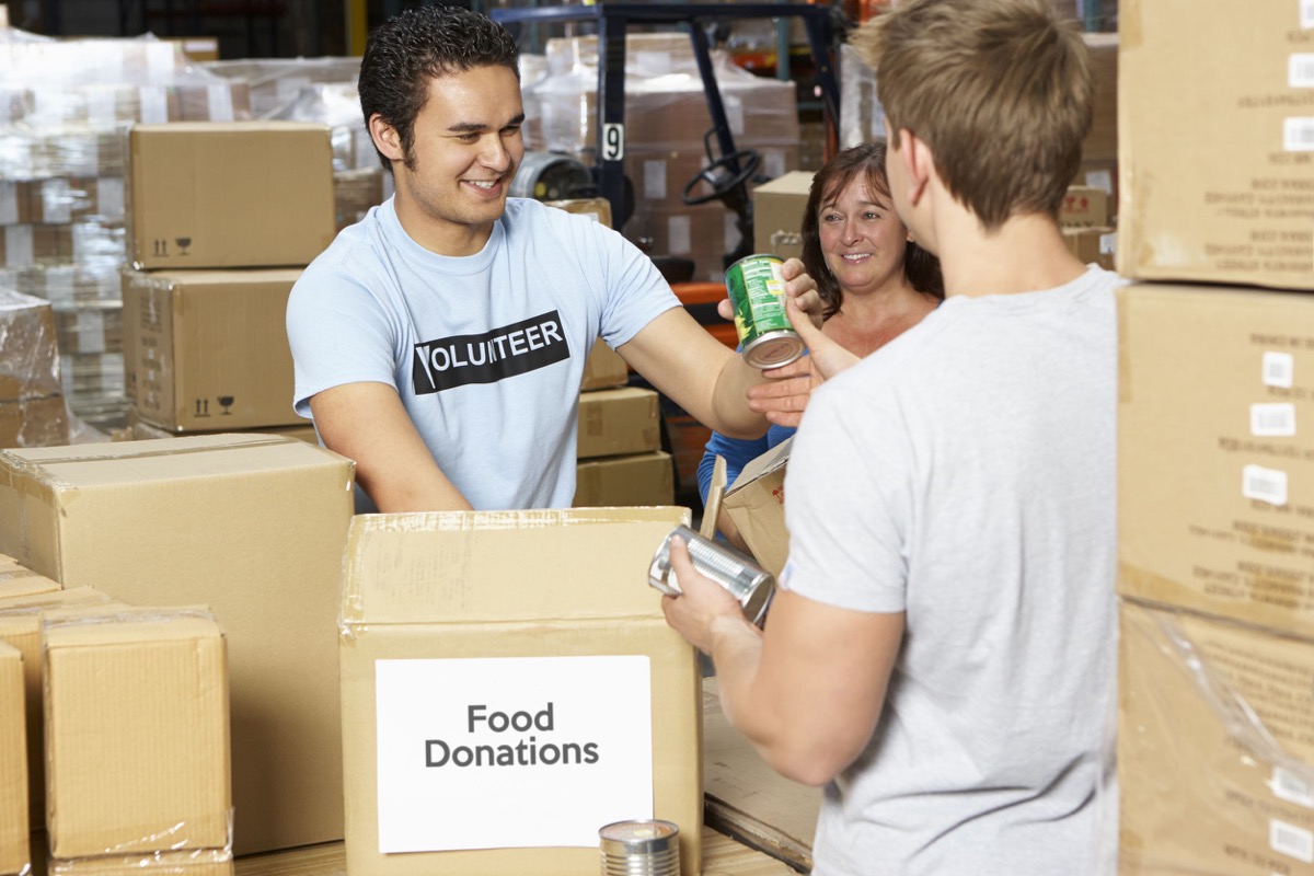 volunteers collecting food donations in warehouse; unions communities concept