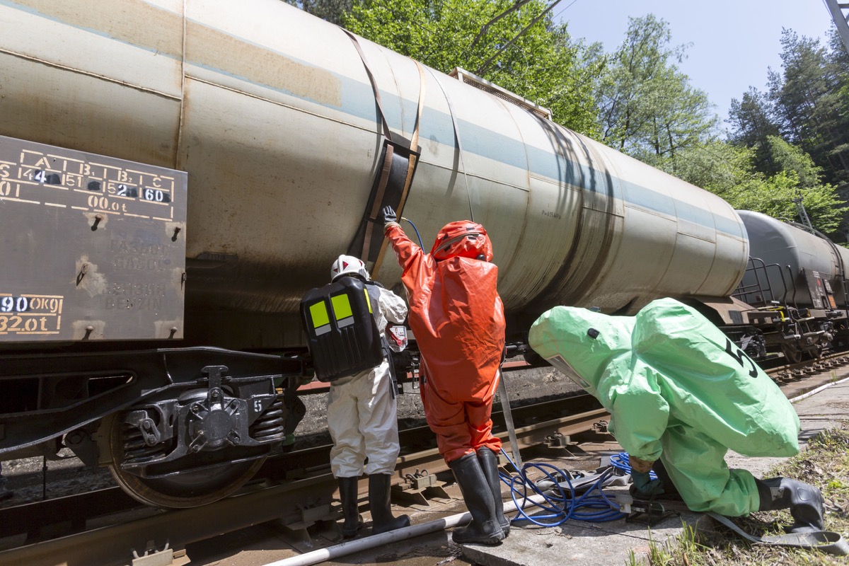 A team working with toxic acids and chemicals is securing a chemical cargo train; Transportation unions concept