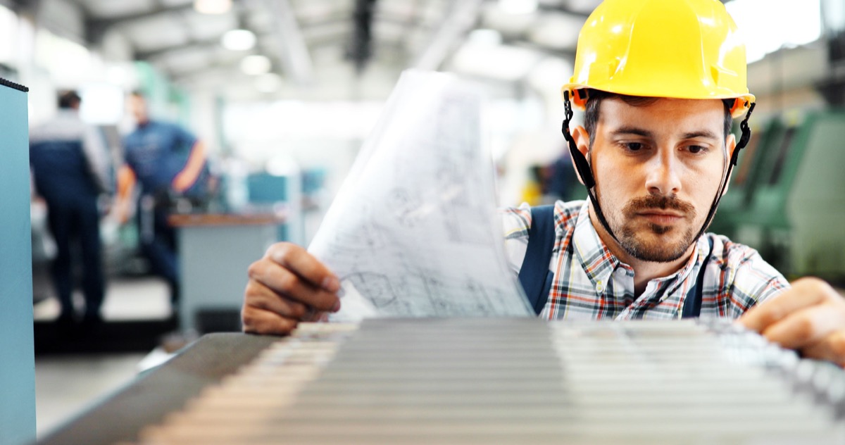 Portrait of an engineer working in metal industry factory; IAM essential workers concept
