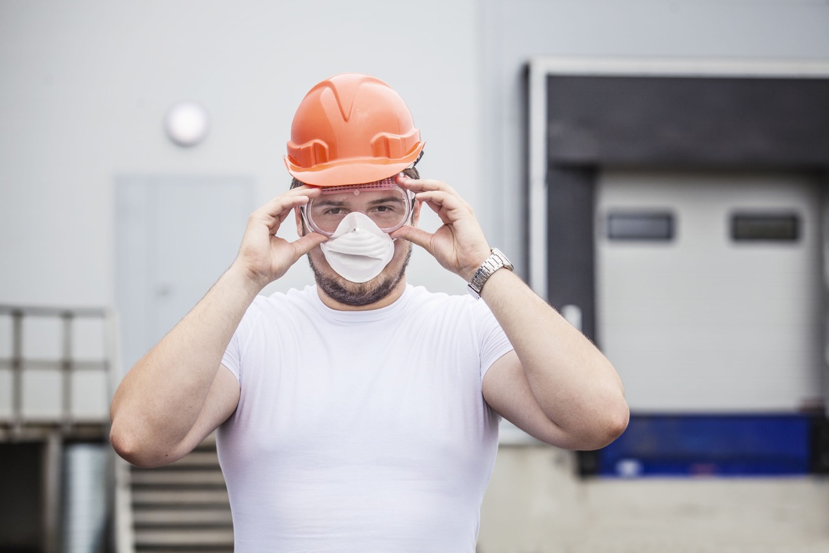 worker in protective mask and glasses in the helmet. Construction, safety, performance; COVID-19 digital Toolkit concept
