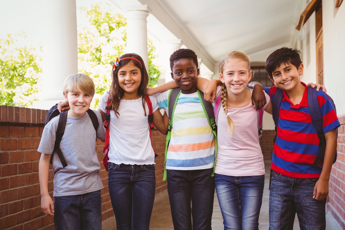 Portrait of smiling little school kids in school corridor; United Federation of Teachers union nyc schools concept
