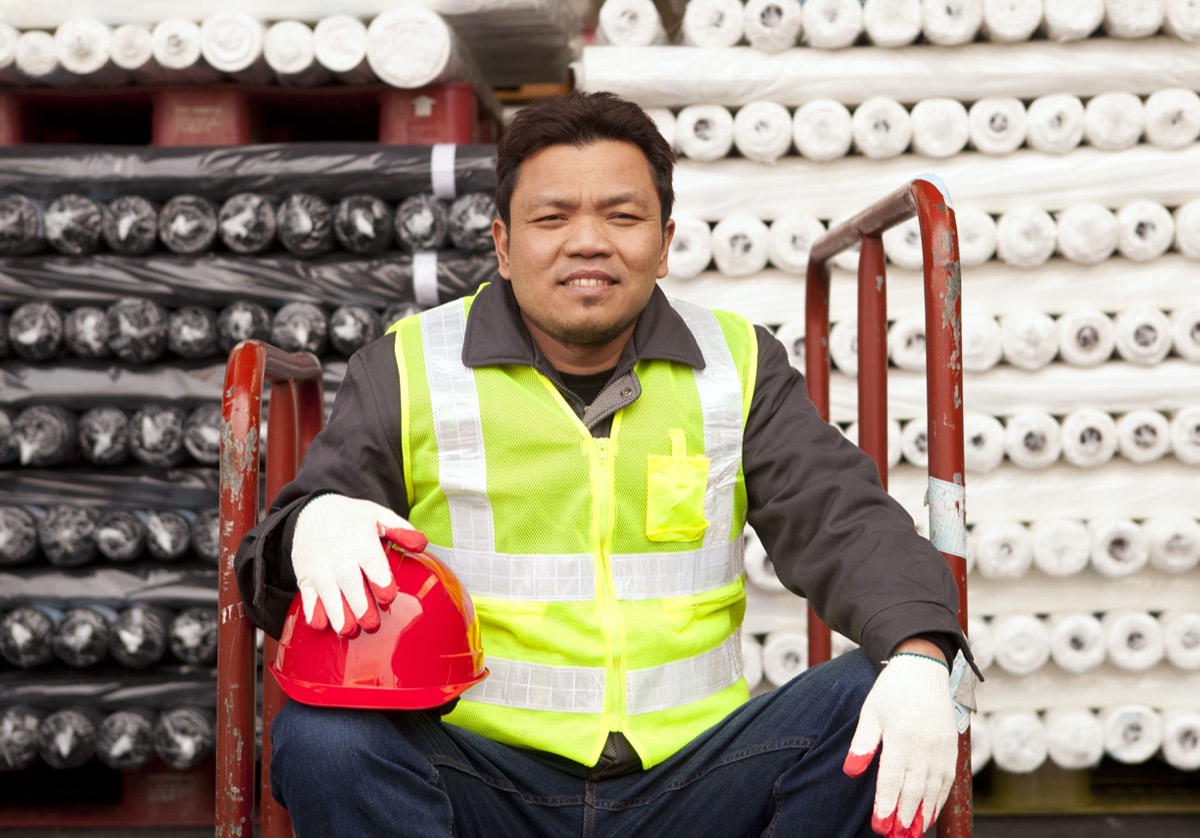 Textile factory worker sitting beside raw material fabrics stacked; NLRB’s new proposed privacy rule concept