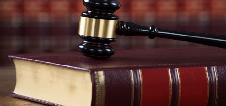 Closeup of mallet on legal book at table in courtroom