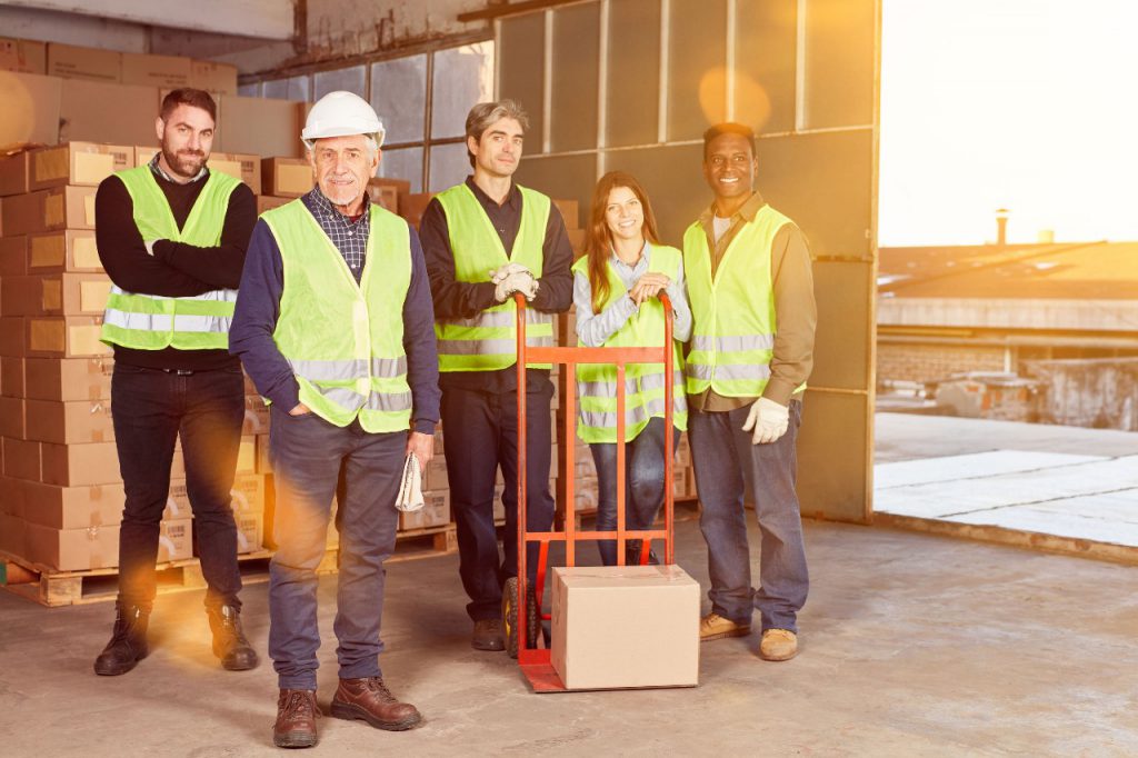 warehouse workers smile at camera; Alabama Amazon union vote concept