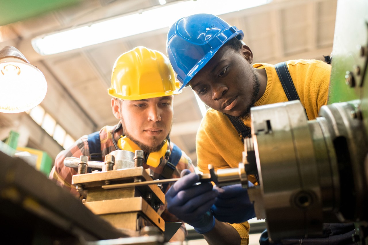 two workers examine factory equipment; Biden and pro-union president concept