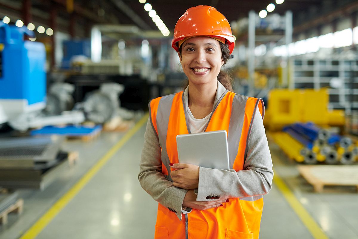 cheerful young woman wearing hardhat smiling happily; unions helping women return to work concept