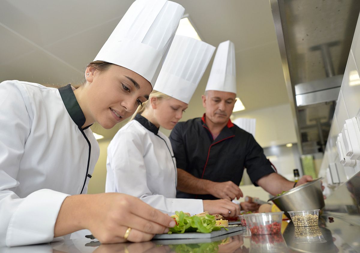 Team of young chefs preparing delicatessen dishes