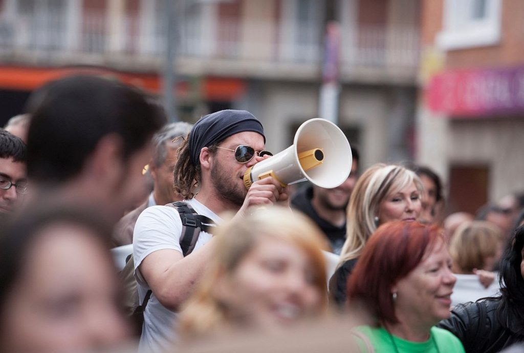 Badajoz, Spain - March 29, 2012: young demostrator with megaphone protesting against austerity cuts, March against the Labor Reform approved by the Government of Spain on March 2012
