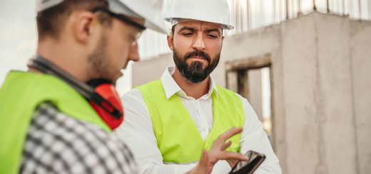 builders in protective hardhats using smartphone; ; digital union-busting concept