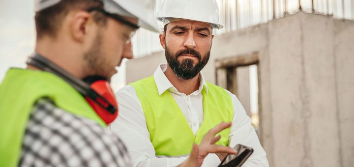 builders in protective hardhats using smartphone; ; digital union-busting concept