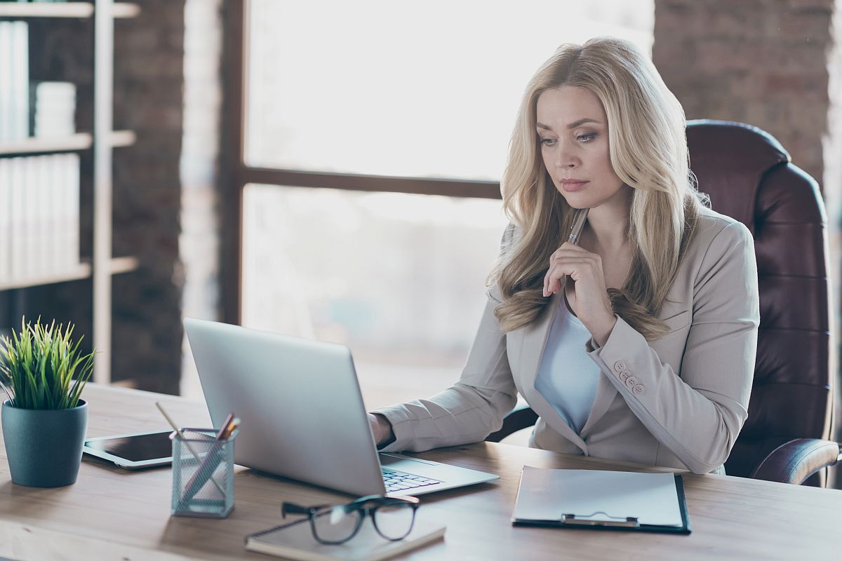 Businessperson uses laptop in modern office; digital union-busting concept