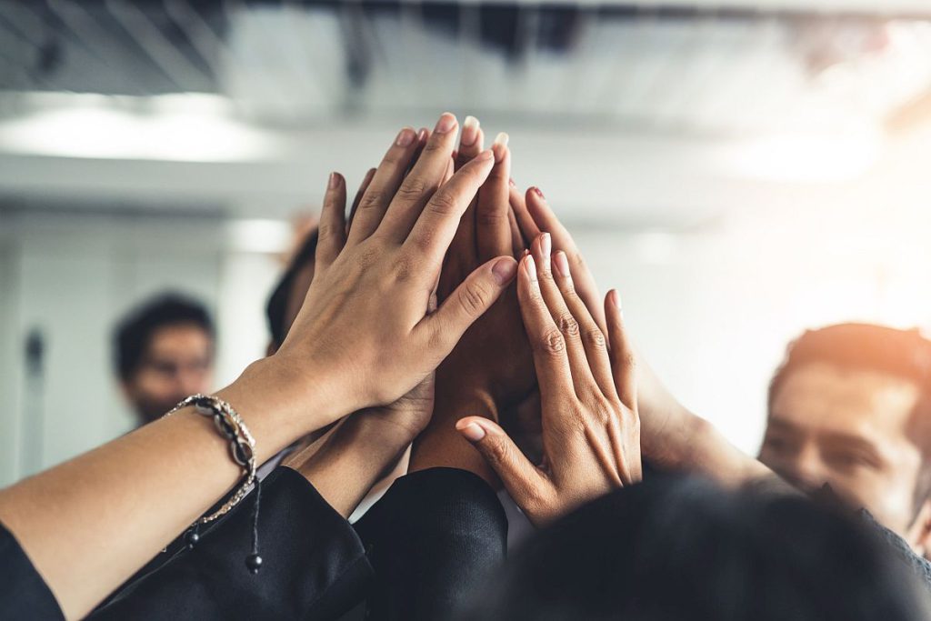 Group of people giving high-fives; unions working together concept