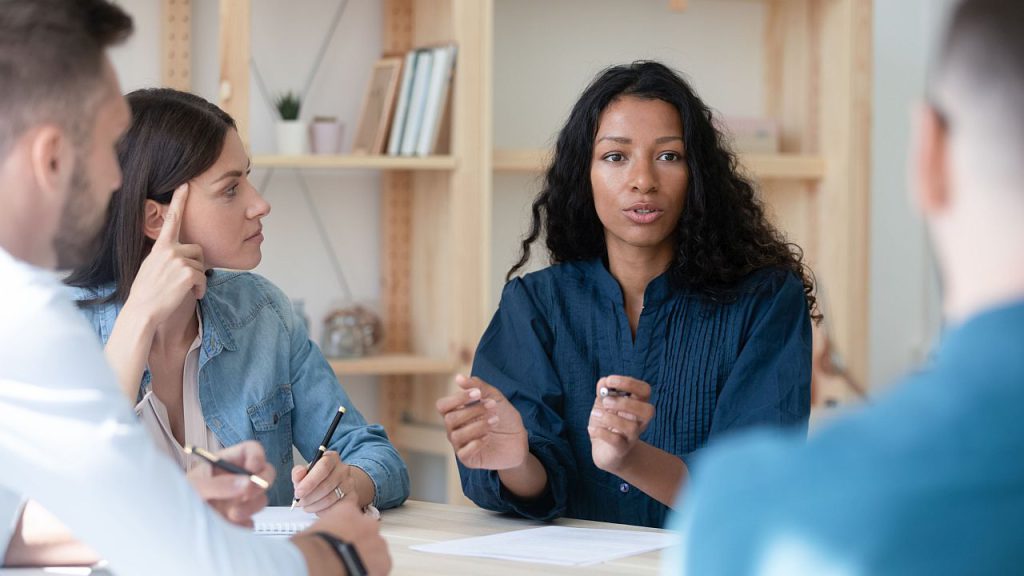 workers talking at a table; collective bargaining concept