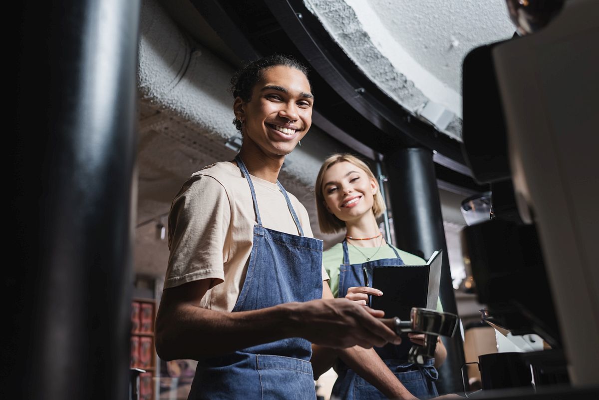 Smiling baristas in coffee shop; worker wins winter 2023 concept