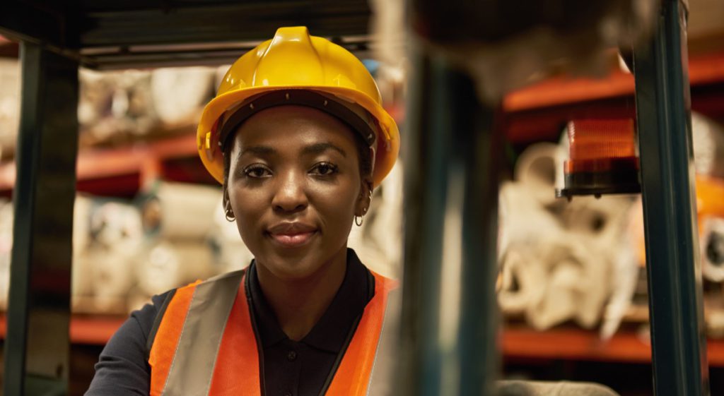 Worker in safety vest and yellow hard hat; unions impact wages concept