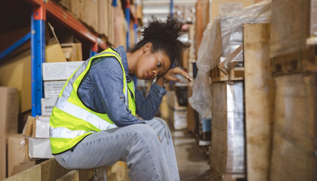 Tired warehouse worker taking a break; right to work myth concept