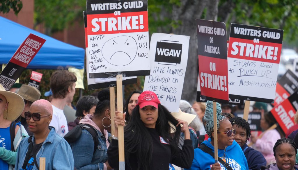 Striking WGA members picketing; WGA Writers strike concept