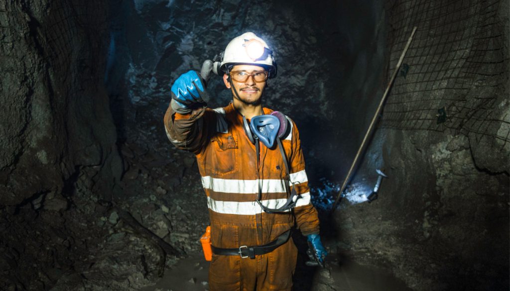 Miner giving thumbs up in a mine; support workers concept