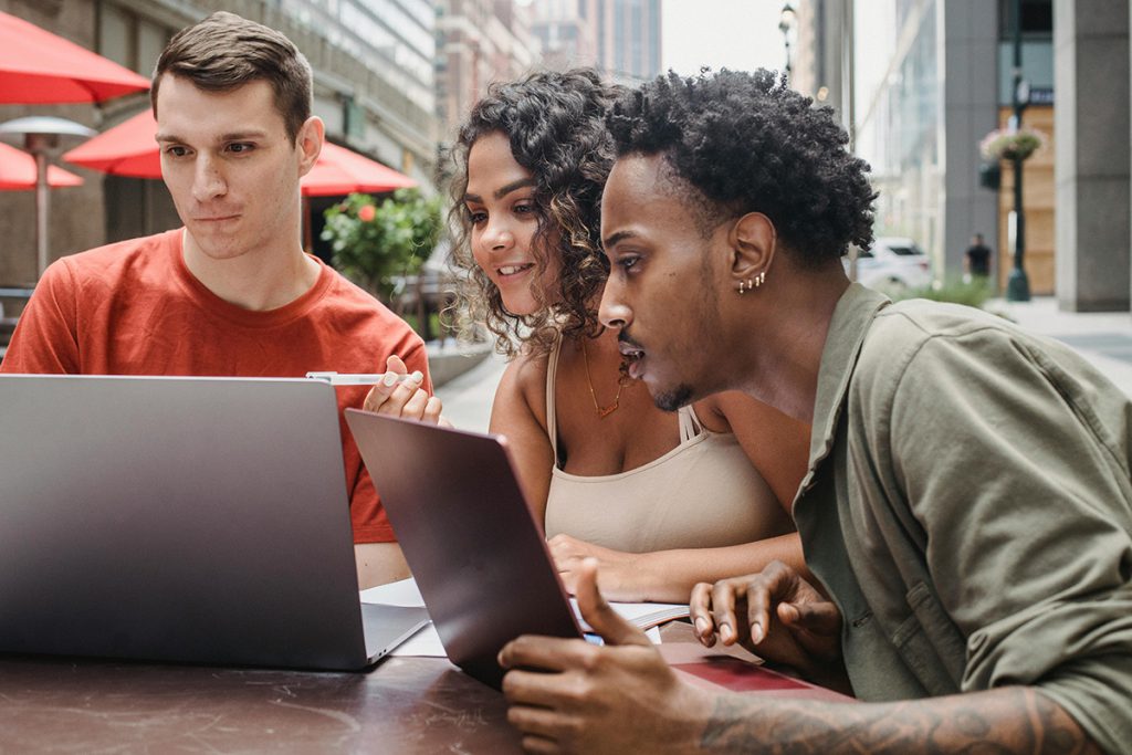 three people reading digital newsletter